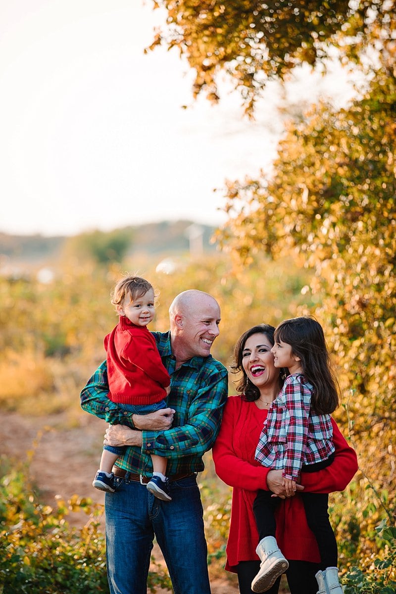 Family in red and plaid around trees