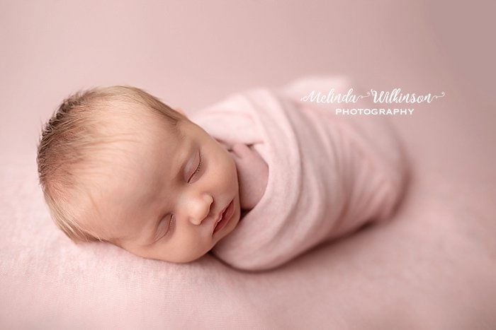 Newborn girl wrapped in pink