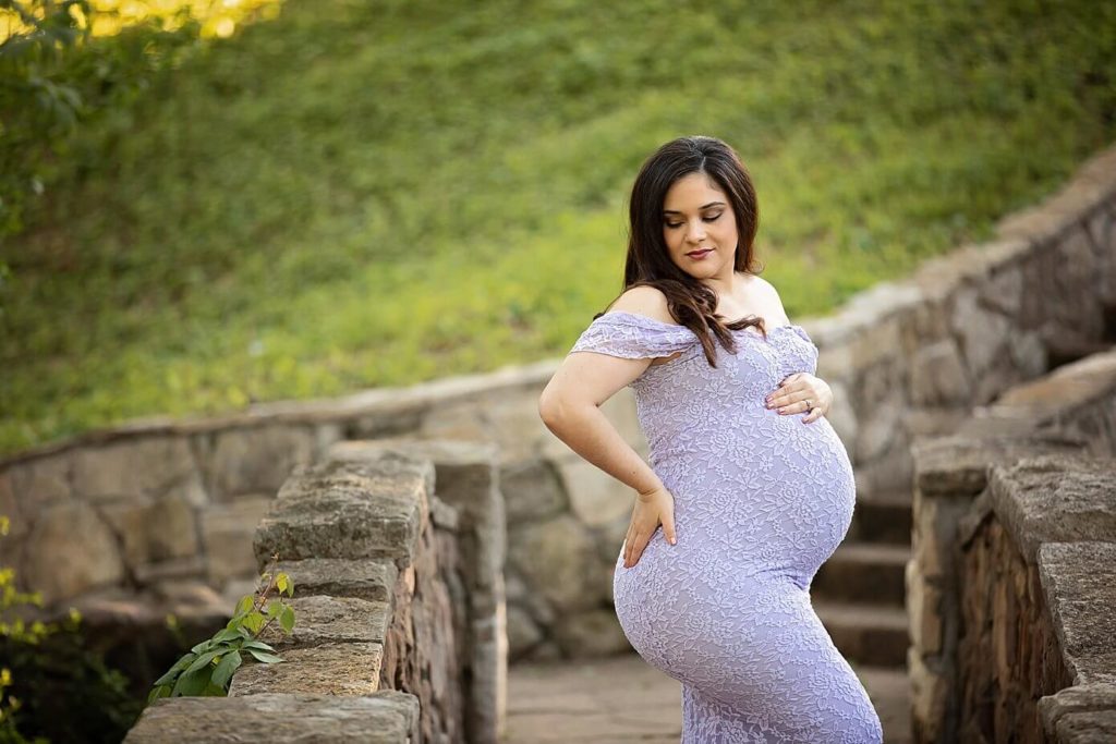 maternity photography in dallas at Davis park in purple gown on bridge