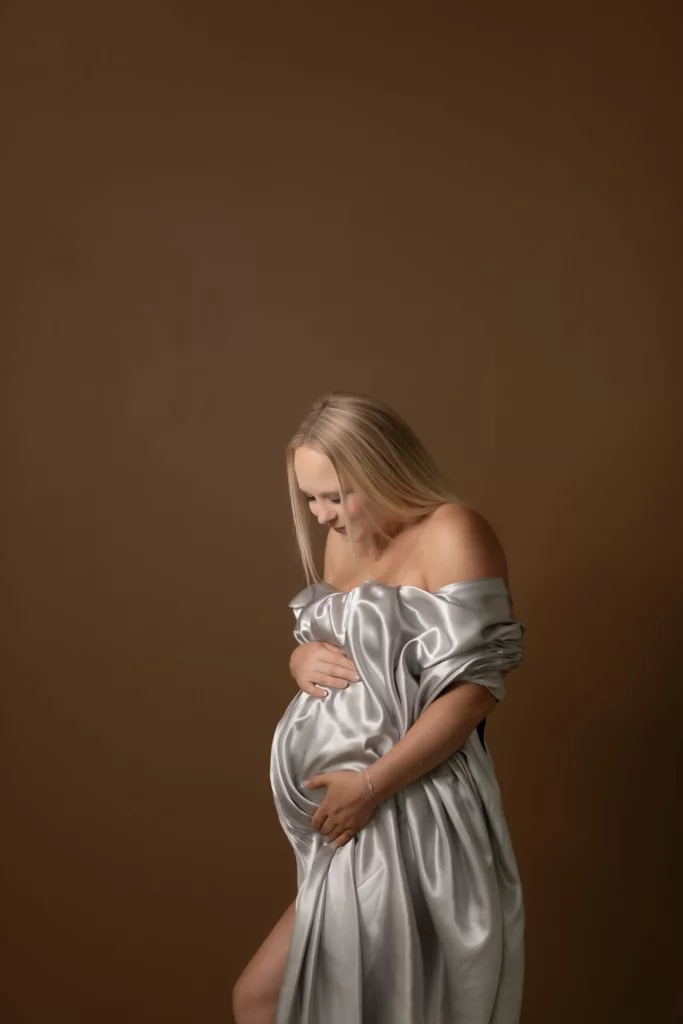 Silver maternity fabric in studio on brown backdrop